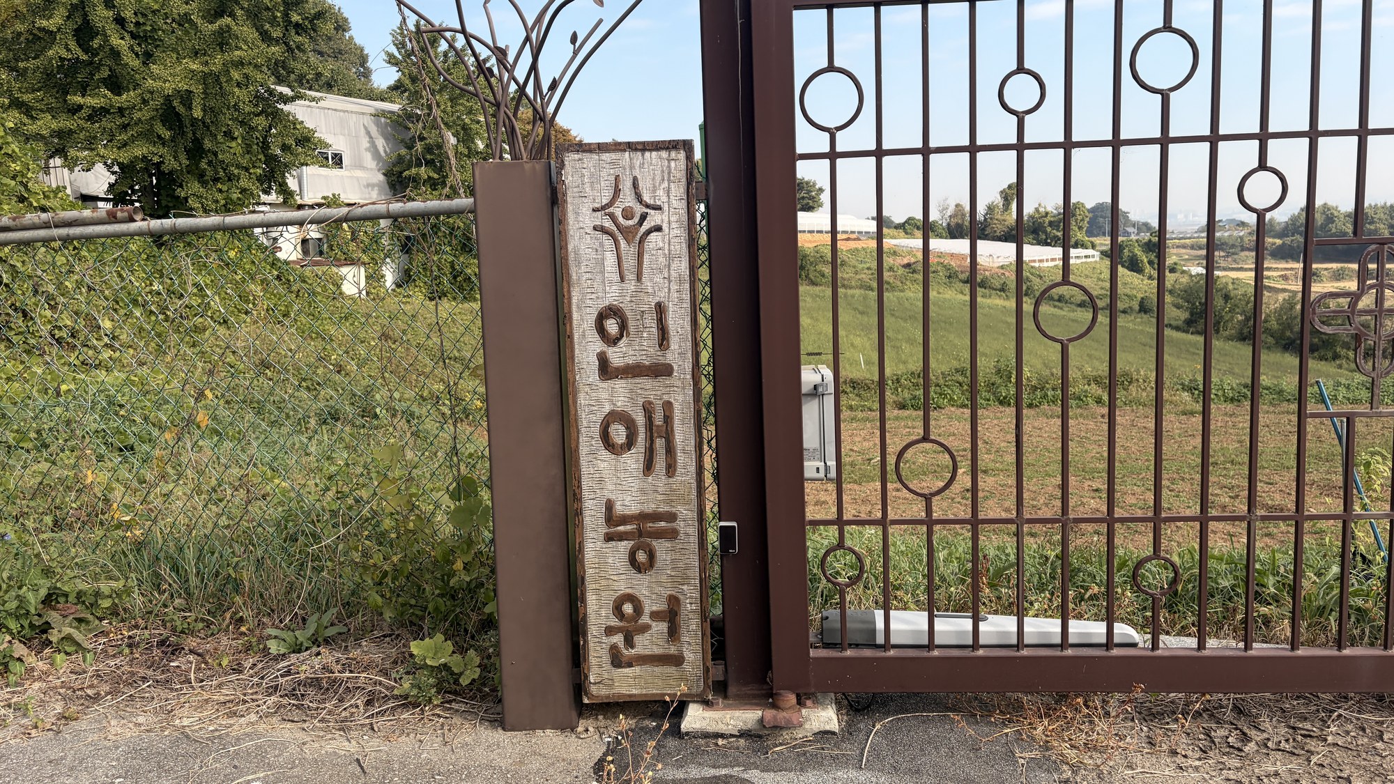 철문 옆에 세워진 ‘인애농원’ 나무 문패