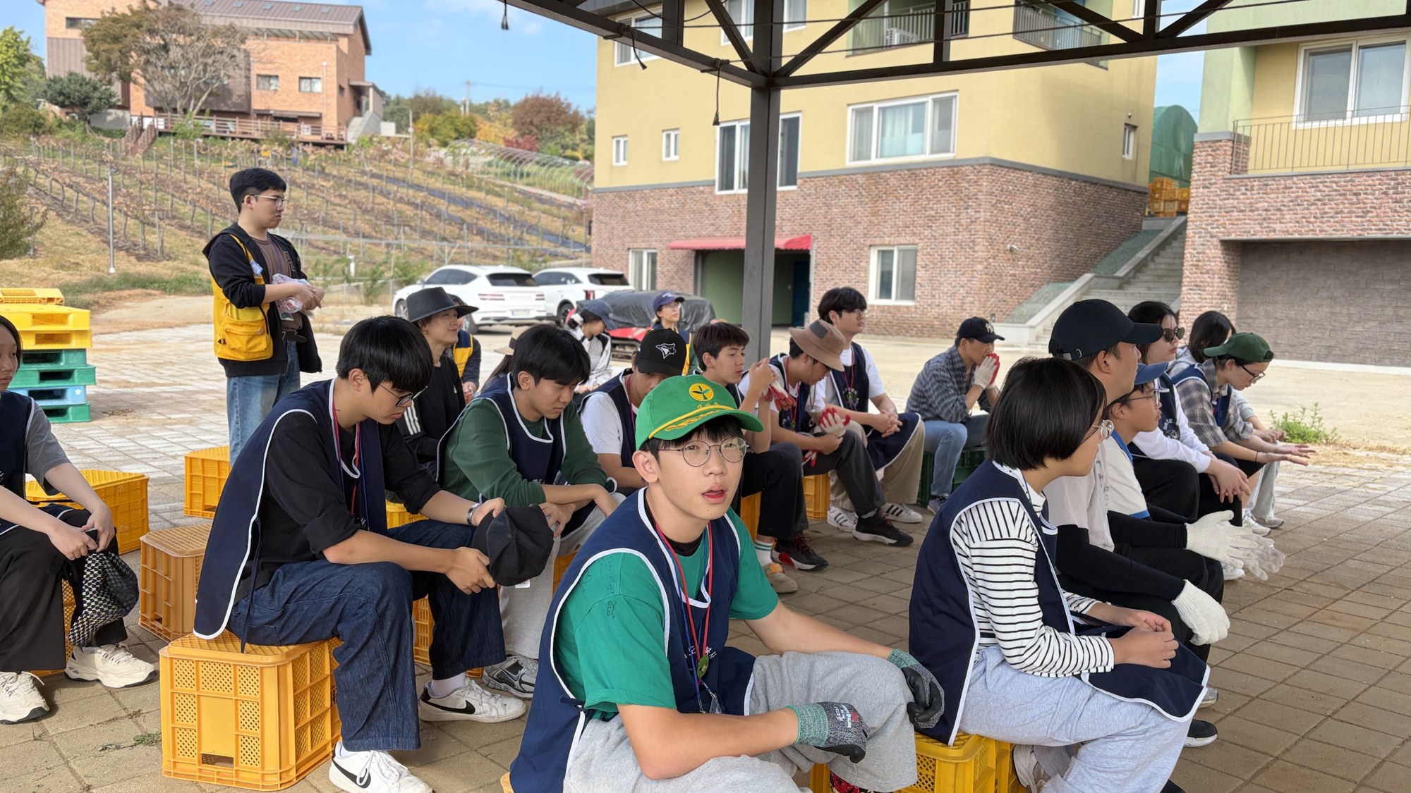 노란 상자에 앉아 이야기를 듣는 청소년들