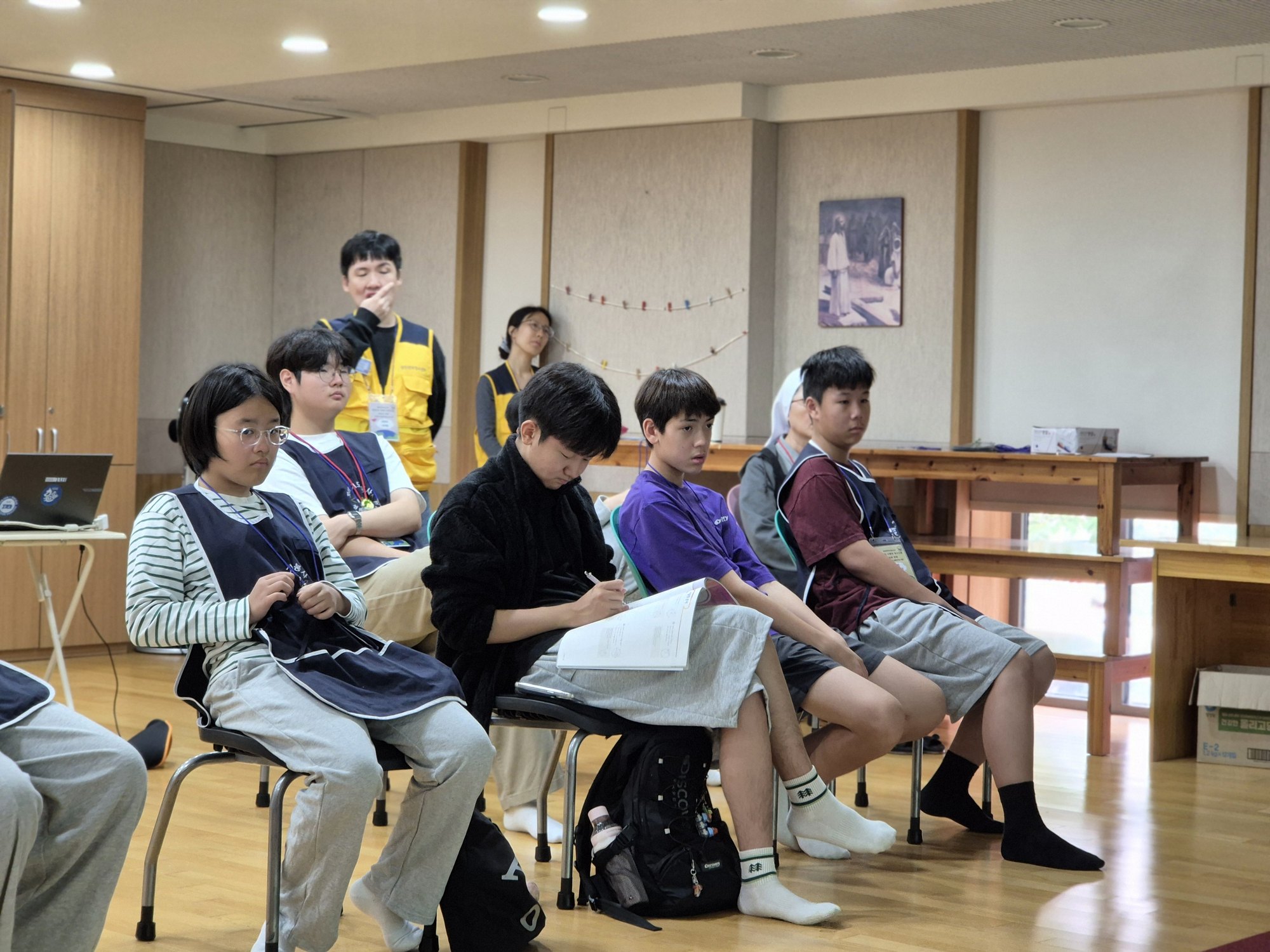 봉사가운을 입고 OT를 듣는 친구들
