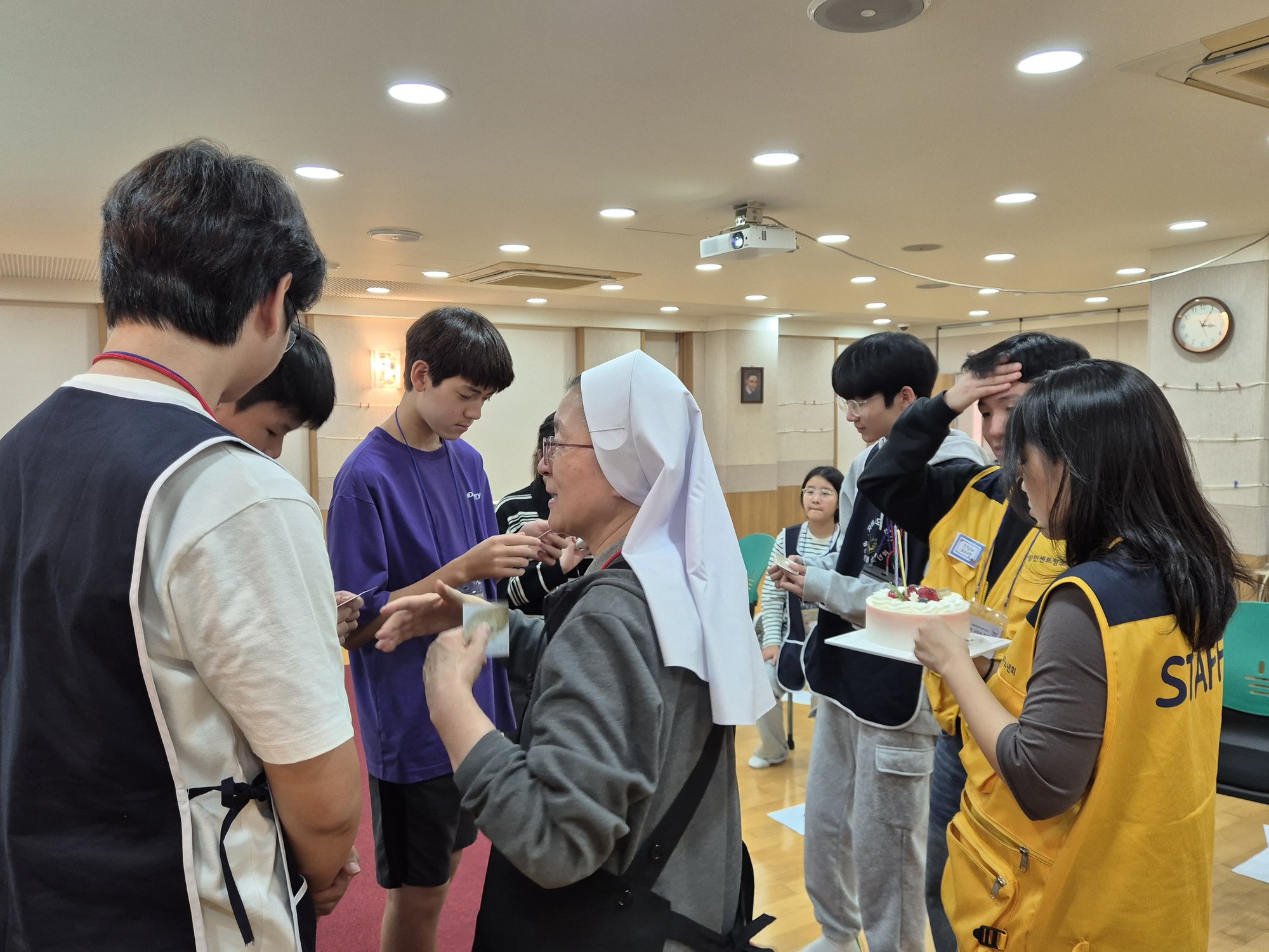 수녀님이 웃으며 축일 친구들에게 카드를 나눠 주는 모습