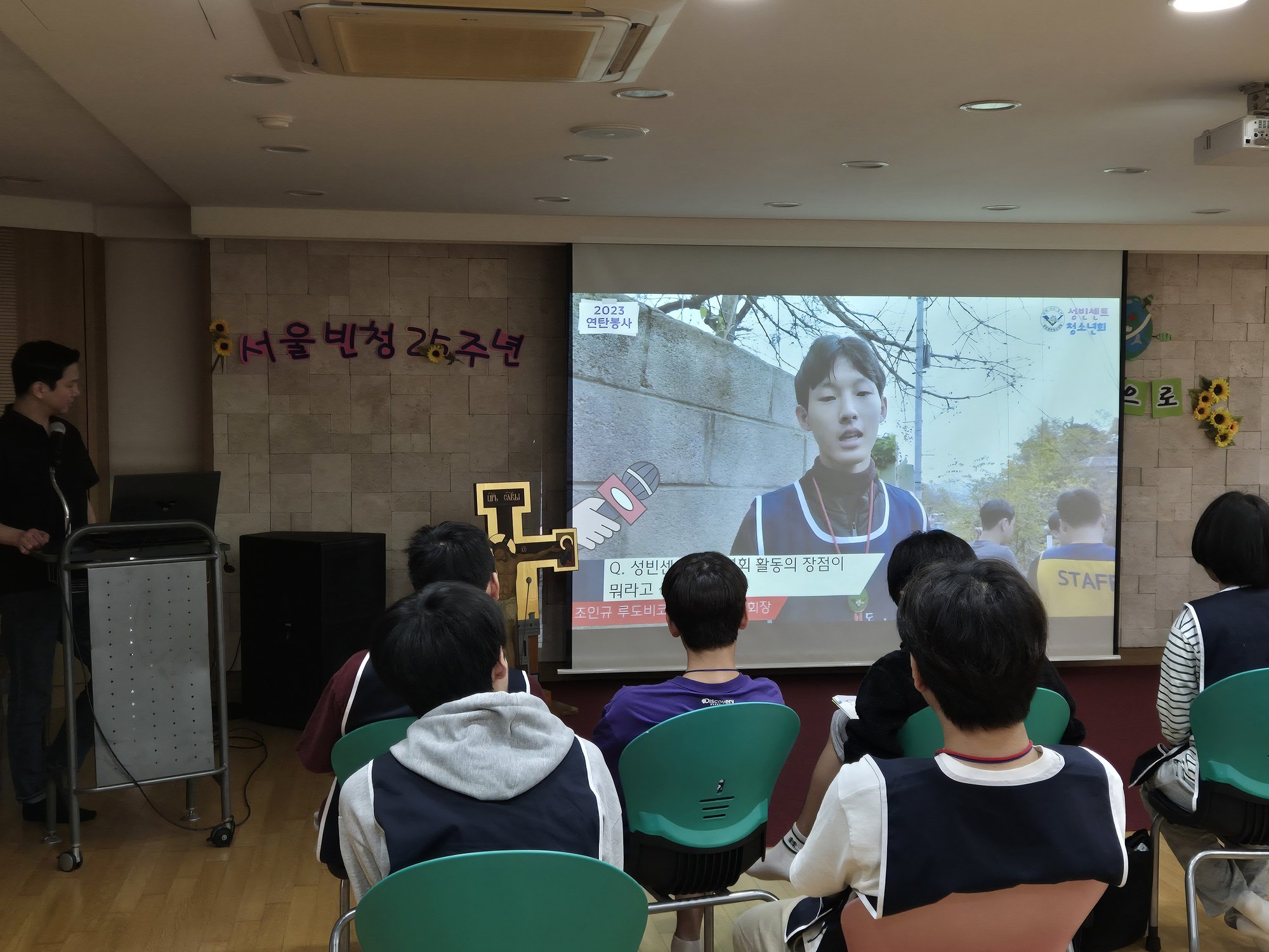 2023 연탄봉사 영상 속 인터뷰 장면을 보는 친구들