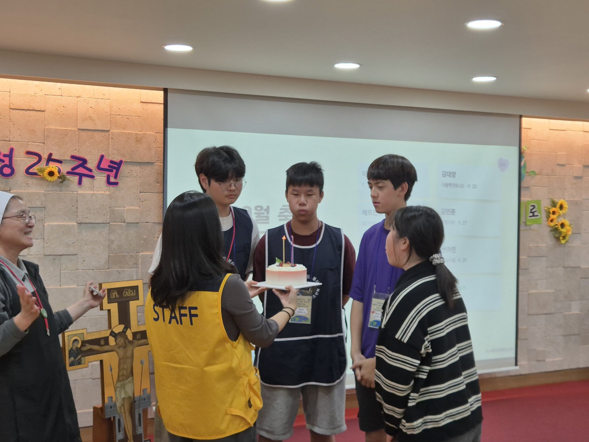 케이크 앞에서 노래를 듣는 친구들
