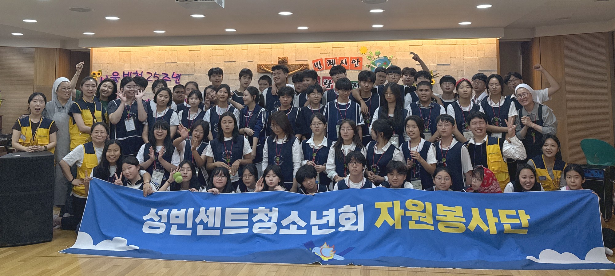 ‘성빈센트청소년회 자원봉사단’ 현수막을 들고 환하게 웃는 빈청 청소년들과 지도자, 수녀님들