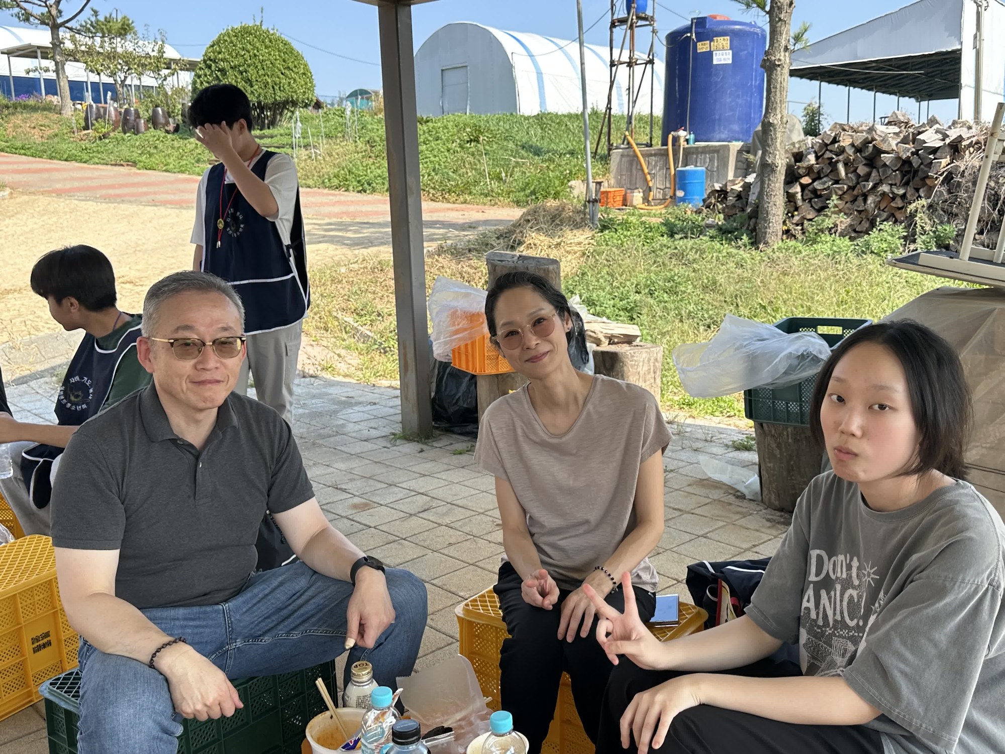 상자에 걸터앉아 쉬며 카메라를 보고 웃는 어른들