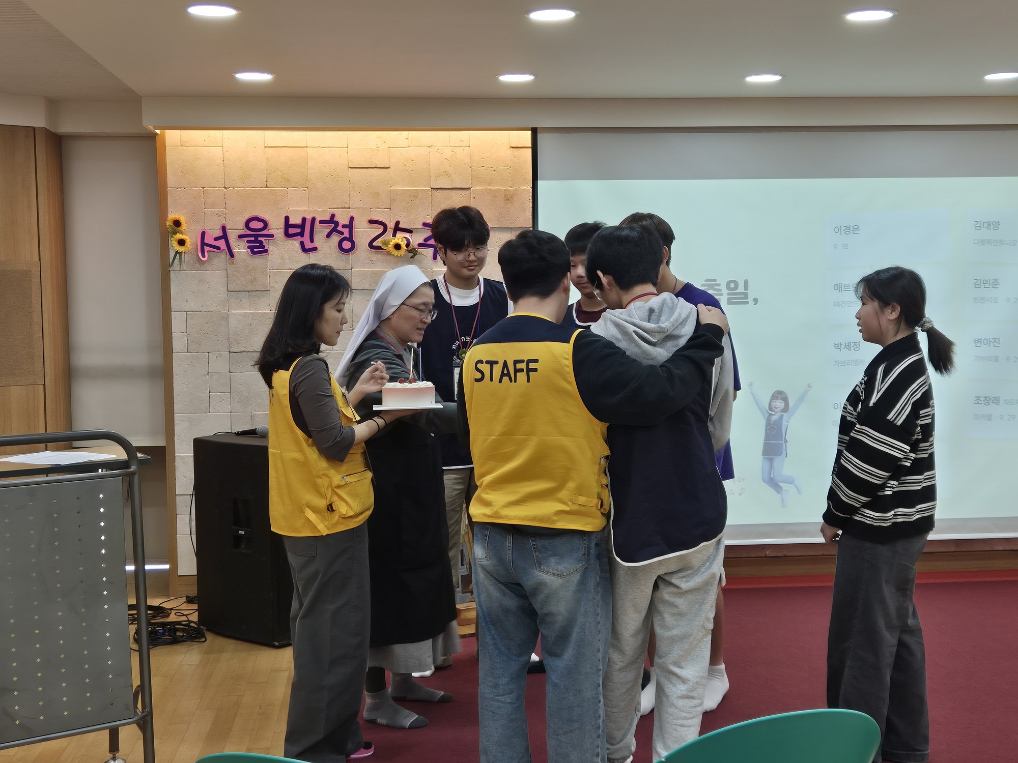 케이크 둘레에 모인 수녀님과 선생님, 친구들