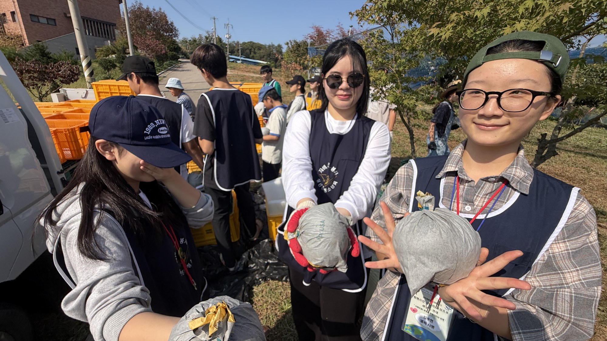 딴 배를 카메라 앞으로 내밀어 보이는 세 사람